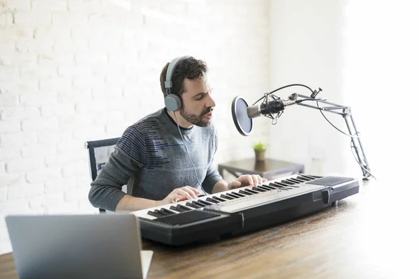 Handsome young latin man playing piano and singing into microphone — podcast, male - Stock Photo | #197737456